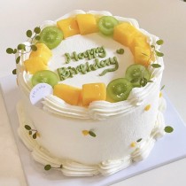 Torta di compleanno a forma di rotonda con uva verde e mango