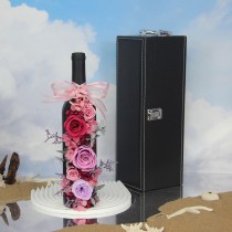 Konservierte Rosen und Hortensienblüten in einer Flasche Rotwein