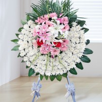 Couronne funéraire - Chrysanthème blanc, feuilles vertes, lys blancs et roses, gerberas roses et rouges