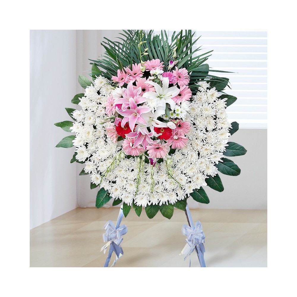 Couronne funéraire - Chrysanthème blanc, feuilles vertes, lys blancs et roses, gerberas roses et rouges