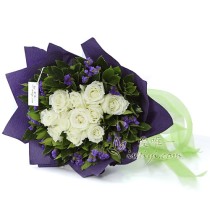 11 blooming white roses accented by purple statice and fresh greens.