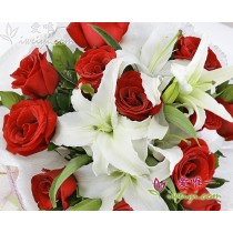 12 premium red roses accented by 3 multi-stemmed white perfume lilies