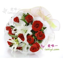 12 rose rosse premium accentuate da 3 gigli bianchi profumati a più steli e verdure fresche.